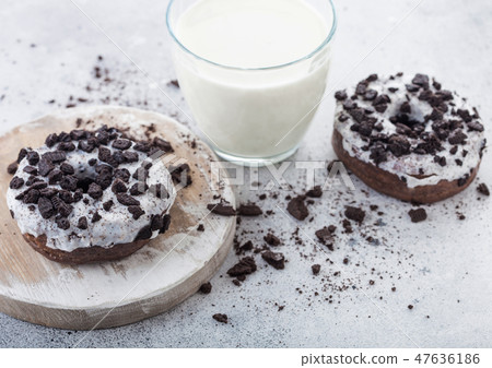 Glass of milk and doughnuts with black cookies Glass of milk and doughnuts with black cookies 47636186