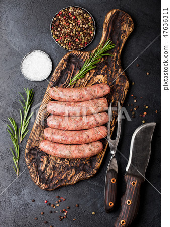 Raw beef and pork sausage on old chopping board Raw beef and pork sausage on old chopping board 47636311