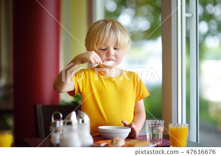 Little boy eating healthy breakfast Little boy eating healthy breakfast 47636676