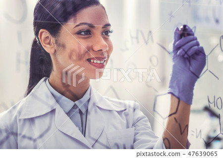 Appealing dark-haired chemist writing chemical formula 47639065