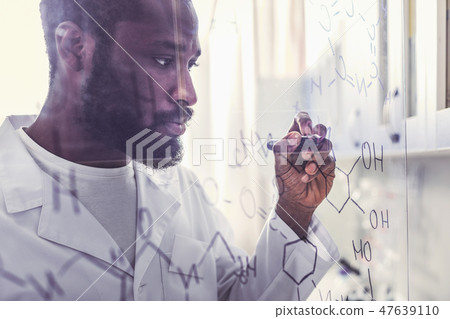 Chemist holding marker pen writing molecular formula Chemist holding marker pen writing molecular formula 47639110