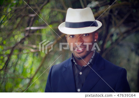 young african man white hat nature smiling  47639164