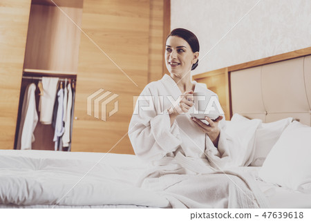 Joyful woman relaxing with cup of tea 47639618