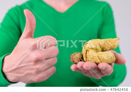 Hands of young man giving thumbs up while holding artificial poo 47642458