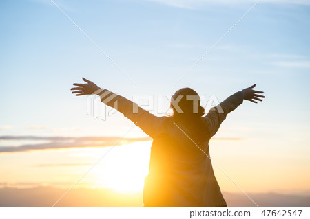 Happy woman standing alone with arms raised up. Happy woman standing alone with arms raised up. 47642547