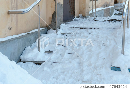 Closeup snowy slippery stairs of the porch in winter day. Camera moving to up. Closeup snowy slippery stairs of the porch in winter day. Camera moving to up. 47643424