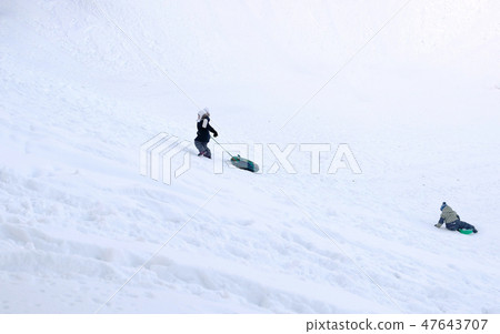 Children ride from the snowy mountains in the tubing in the winter Park. Children ride from the snowy mountains in the tubing in the winter Park. 47643707