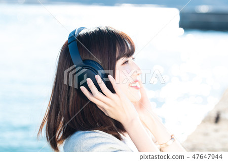 一個年輕的女人，聽聽音樂 47647944