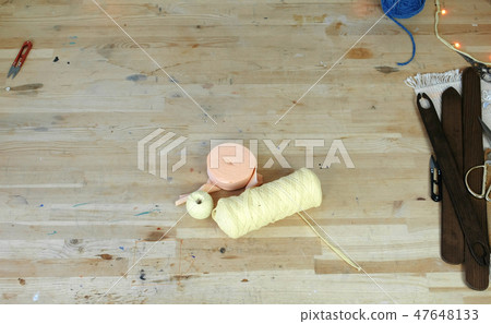 Workplace in sewing and weaving workshop with scissors, yarn, wooden table and shuttle. Workplace in sewing and weaving workshop with scissors, yarn, wooden table and shuttle. 47648133