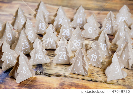 Handmade Christmas advent calendar Christmas trees Kraft paper with numbers in wood background. Handmade Christmas advent calendar Christmas trees Kraft paper with numbers in wood background. 47649720