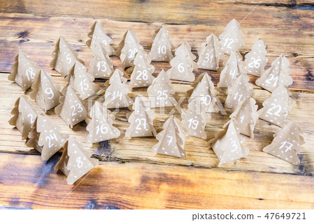 Handmade Christmas advent calendar Christmas trees Kraft paper with numbers in wood background. Handmade Christmas advent calendar Christmas trees Kraft paper with numbers in wood background. 47649721