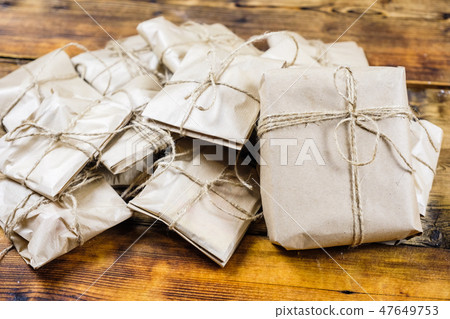 Close-up many gifts wrapped kraft paper on wooden background. One big present. Close-up many gifts wrapped kraft paper on wooden background. One big present. 47649753