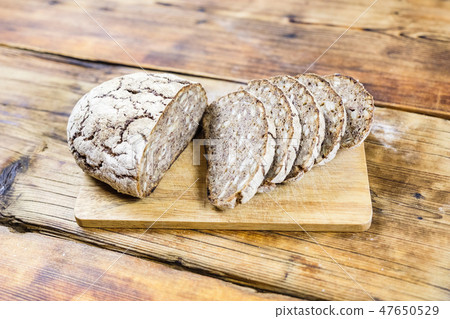 Homemade rye bread with sunflower and pumpkin seeds on wooden background. Side view. Homemade rye bread with sunflower and pumpkin seeds on wooden background. Side view. 47650529
