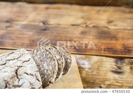 Homemade rye bread with sunflower and pumpkin seeds on wooden background. Left on photo. Homemade rye bread with sunflower and pumpkin seeds on wooden background. Left on photo. 47650530
