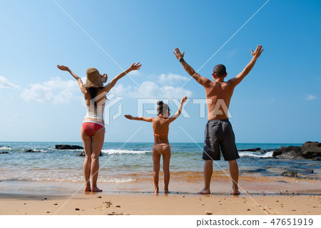 Father and mother and daughter playing on the beach Father and mother and daughter playing on the beach 47651919