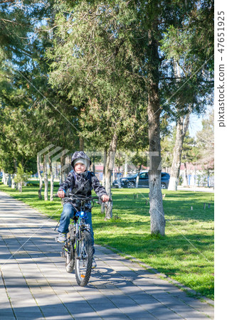 boy riding a bike in the park boy riding a bike in the park 47651925