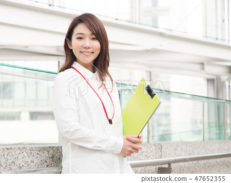 Businesswoman with yellow green file 47652355