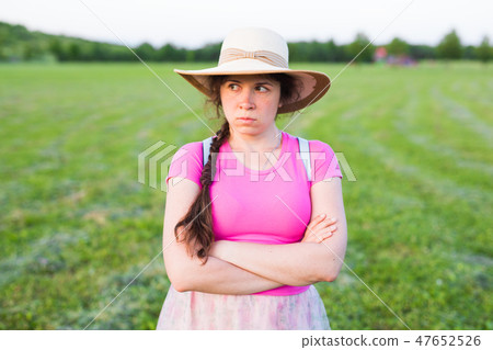 Gloomy bored girl frowns face looking aside. Angry sullen woman standing outdoors waiting for 47652526