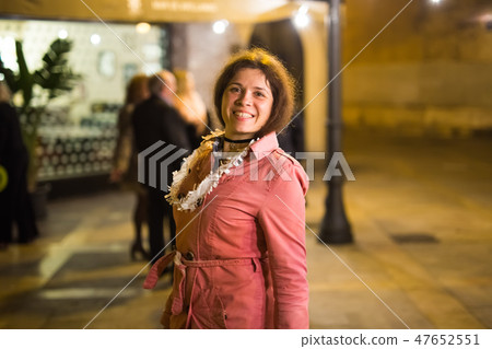 Night street portrait of smiling beautiful young woman after party and looking at camera 47652551