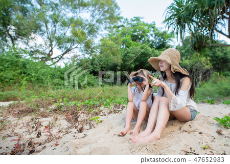 Mother and daughter playing with binoculars Mother and daughter playing with binoculars 47652983
