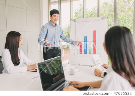 Asian man give a presentation to team 47655523