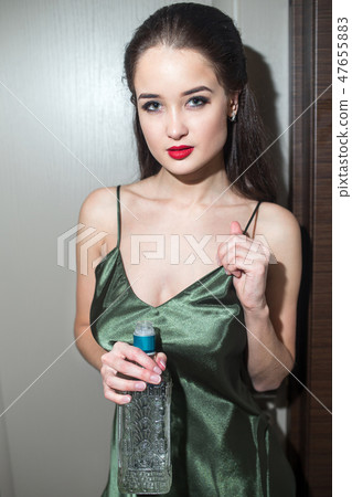 Drunk girl with bottle of whiskey at home 47655883