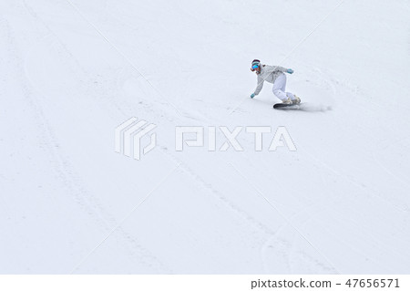 Female snowboarder rocking the slopes in winter Female snowboarder rocking the slopes in winter 47656571
