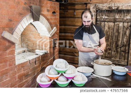 Men knead the dough for bread next to the wooden door and the rainforest Men knead the dough for bread next to the wooden door and the rainforest 47657566