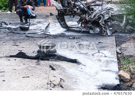 Burned car after an accident on the road. Police at the scene of the accident. Burned car after an accident on the road. Police at the scene of the accident. 47657630