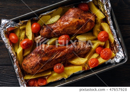 Roasted turkey legs with potatoes and tomatoes. Roasted turkey legs with potatoes and tomatoes. 47657928