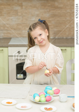 little girl having fun to paint easter eggs little girl having fun to paint easter eggs 47658164