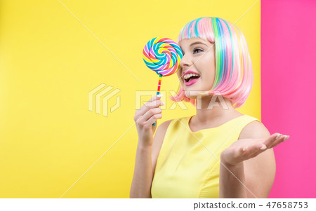 Woman in a colorful wig with a lollipop 47658753