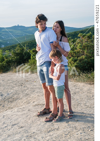 Mom dad and son don't want to be photographed on the mountain with seascape. Family photo. Mom dad and son don't want to be photographed on the mountain with seascape. Family photo. 47659221