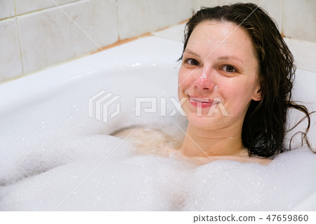 young beautiful girl in a bath with foam young beautiful girl in a bath with foam 47659860