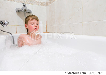 a child playing in a bubble bath at home 47659976