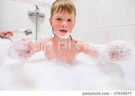 a child playing in a bubble bath at home 47659977