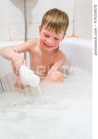beautiful child taking a relaxing bath with foam and using cosmetics 47659978