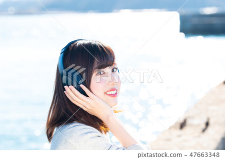 A young woman listening to music 47663348