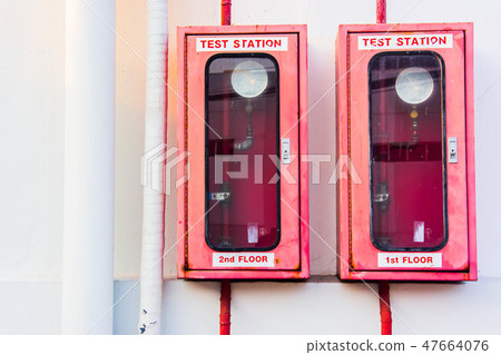 Fire Extinguisher in red cabinet on white wall Fire Extinguisher in red cabinet on white wall 47664076