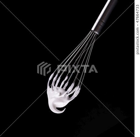 Metal whisk with whipped egg whites, isolated on black background. Clipping path. 47664733