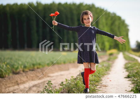 Little girl walking in nature field wearing beautiful dress 47666225