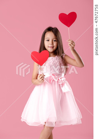 cute little girl in a pink dress holding a paper heart cute little girl in a pink dress holding a paper heart 47672758