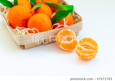 Tangerines with green leaves in a basket Tangerines with green leaves in a basket 47672765