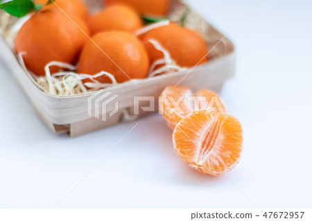 Tangerines with green leaves in a basket  47672957