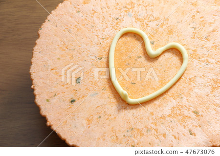 Shrimp crackers with a heart mark drawn in mayonnaise. 47673076