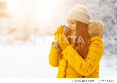 Cute girl enjoying coffee on a winter day.  47673458