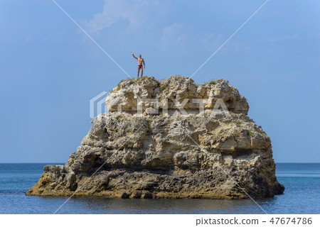 A man stands on top of a cliff A man stands on top of a cliff 47674786