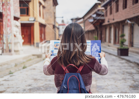 Young woman traveler walking in the old town 47676180