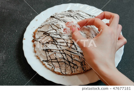 Close-up of hand woman takes cherry from homemade cherry pie on white plate. Close-up of hand woman takes cherry from homemade cherry pie on white plate. 47677181