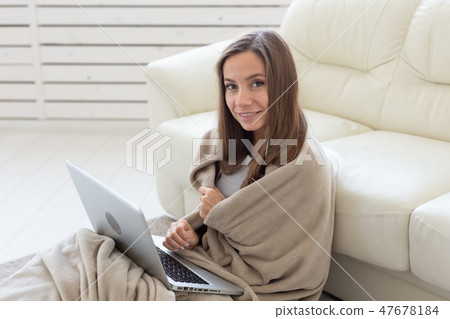 Freelance, cozy, comfort concept - young woman in plaid sitting on the floor and chatting the net Freelance, cozy, comfort concept - young woman in plaid sitting on the floor and chatting the net 47678184